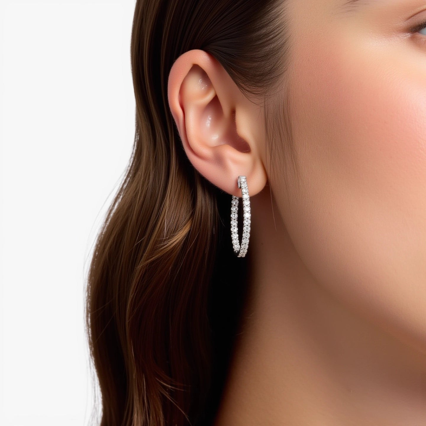Certainly! Here's an alternative version with a more refined tone:

The model showcases our elegant inside-out hoop earrings, adorned with 40 round lab grown diamonds totaling 2.00 carats. Crafted in your choice of 14K or 18K gold and platinum, each prong-set diamond offers exceptional visibility. The hoops feature a hinged snap closure and rhodium plating, measuring 0.84" by 0.08" | Adorn By You