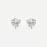 The image shows two stud earrings made from yellow gold. Each earring features a single round brilliant-cut diamond held in a three-prong setting that tapers elegantly toward the stone. Designed to be worn on the earlobes, the studs are shown unattached and arranged side by side on a seamless white surface. Crisp, even studio lighting creates a high-key look with soft shadows beneath the earrings, emphasizing their sparkle and symmetry.  | Adorn By You