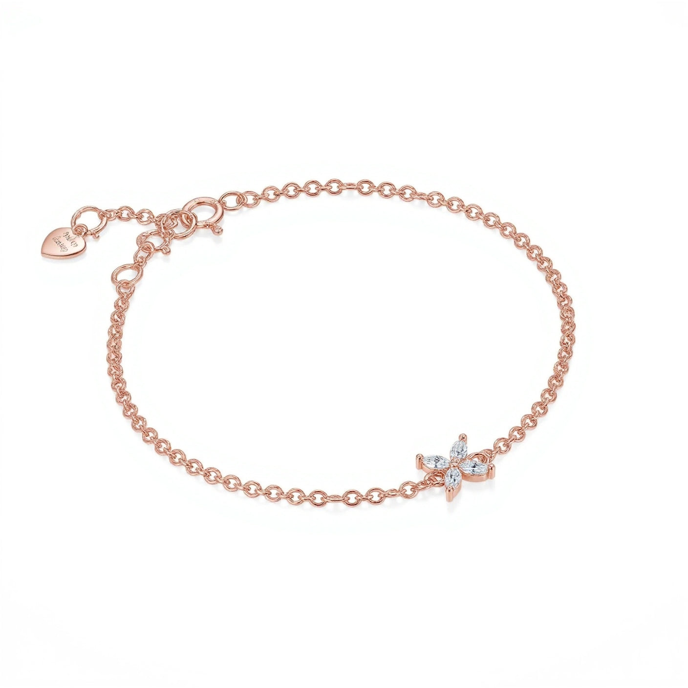 One rose gold chain bracelet is featured, crafted from delicate polished links with a four-petal flower motif at its center set with marquise-cut clear stones and a tiny signature heart tag with brand name Adorn By You by the spring-ring clasp. The warm metallic hue contrasts subtly with the sparkling white gems, arranged symmetrically in a simple botanical shape. The bracelet is displayed flat against a seamless white background under soft, even studio lighting that eliminates shadows | Adorn By You