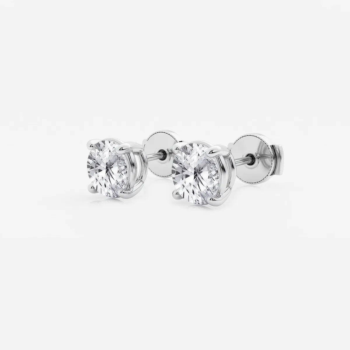 Lab-grown round diamond solitaire studs in 14K/18K gold. VS clarity, 0.25–6 CTW, four-prong, screw-back | Adorn By You